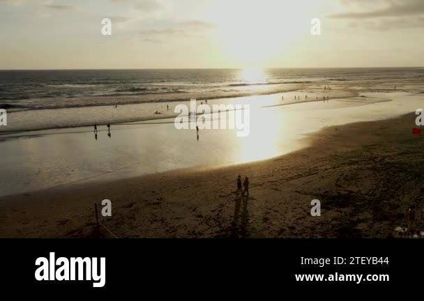 People Enjoy The Romantic Sunset At The Popular Echo Beach In Canggu On