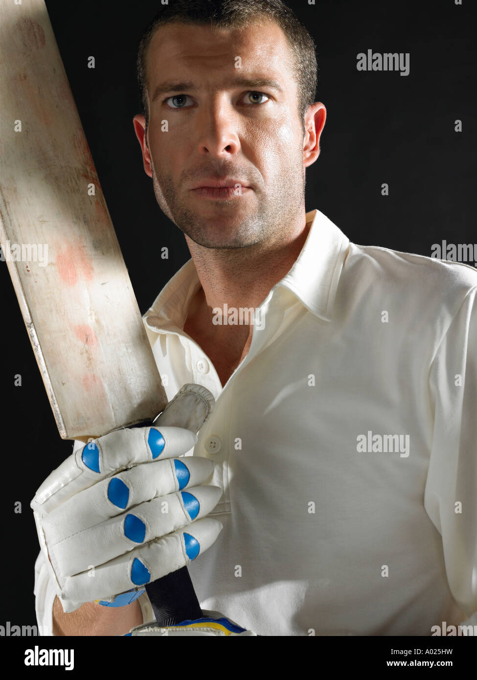 Cricket player holding cricket bat, portrait Stock Photo - cricket-player-holding-cricket-bat-portrait-A025HW