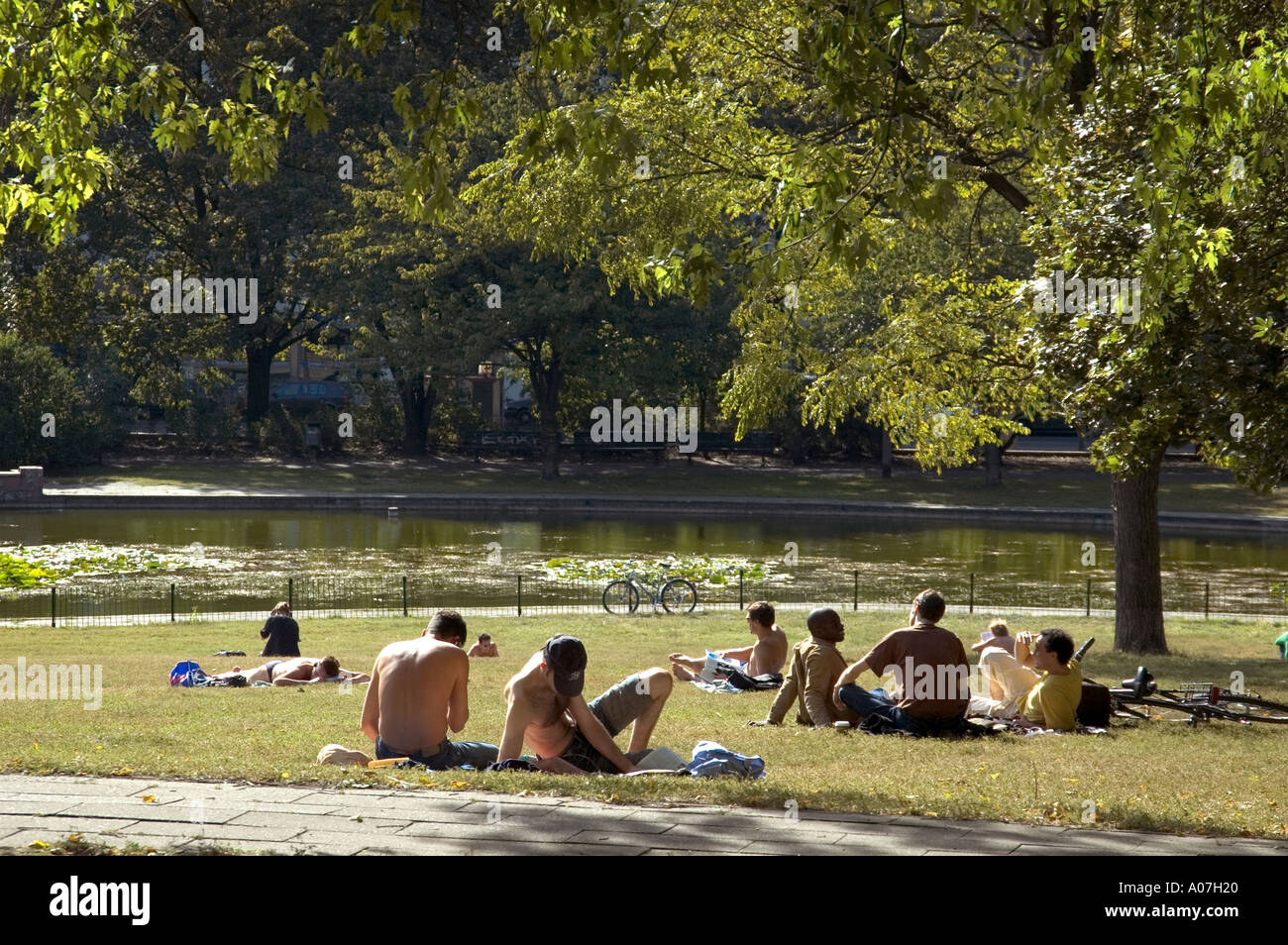 YOUNG PEOPLE SUNBATHING IN LOCAL PARK VOLKSPARK AM WEINBERG MITTE Stock