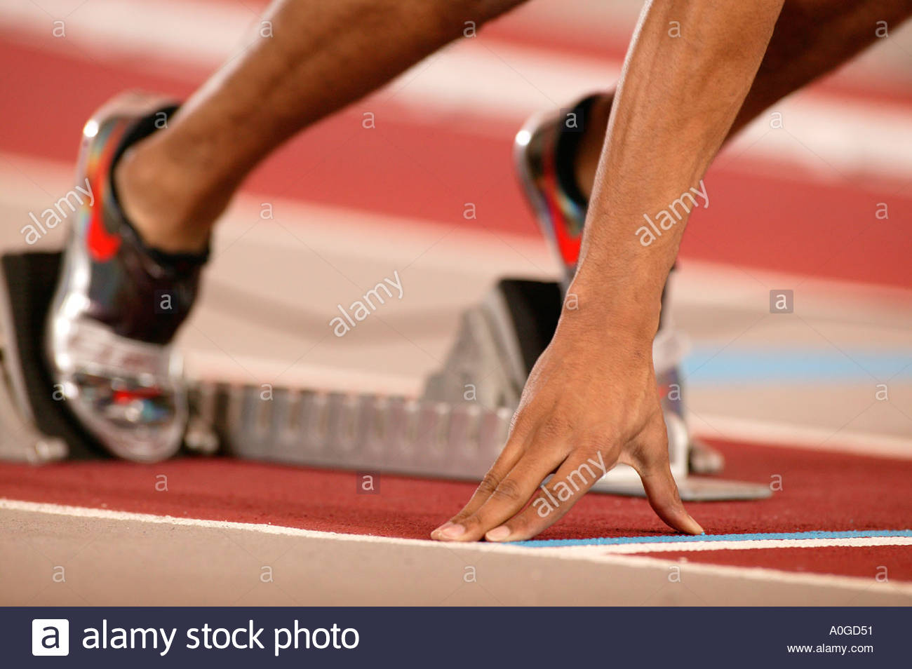 Runner coming out of the starting blocks at an indoor track meet Stock