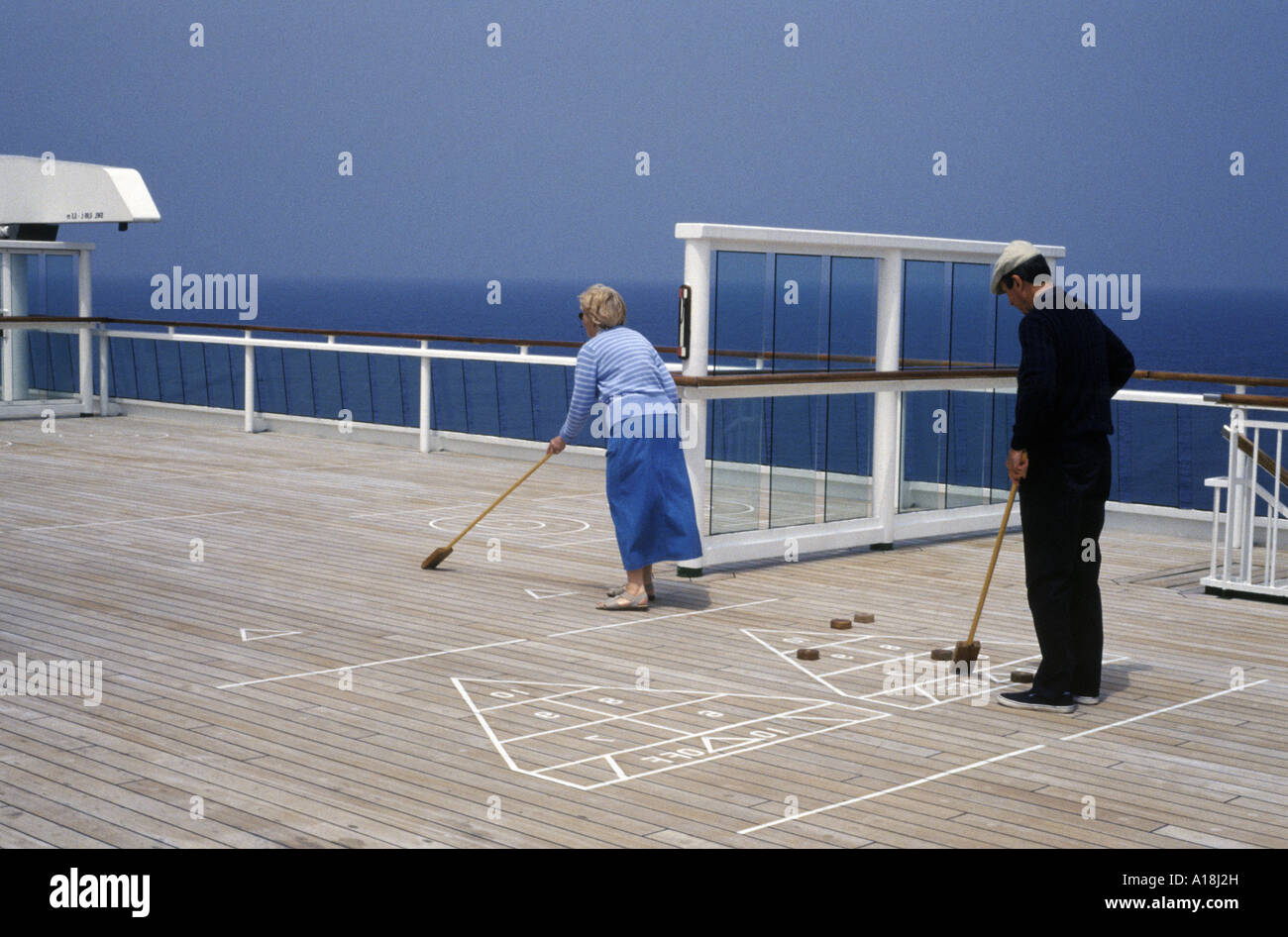 a couple playing deck shuffleboard on a cruise ship Stock Photo