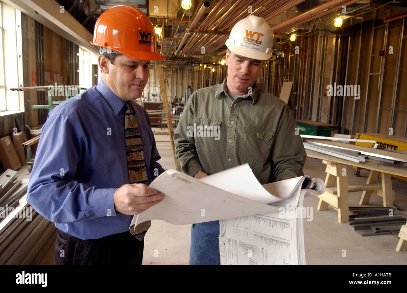 architect and construction foreman look over schematic drawings architect and construction foreman look over schematic drawings