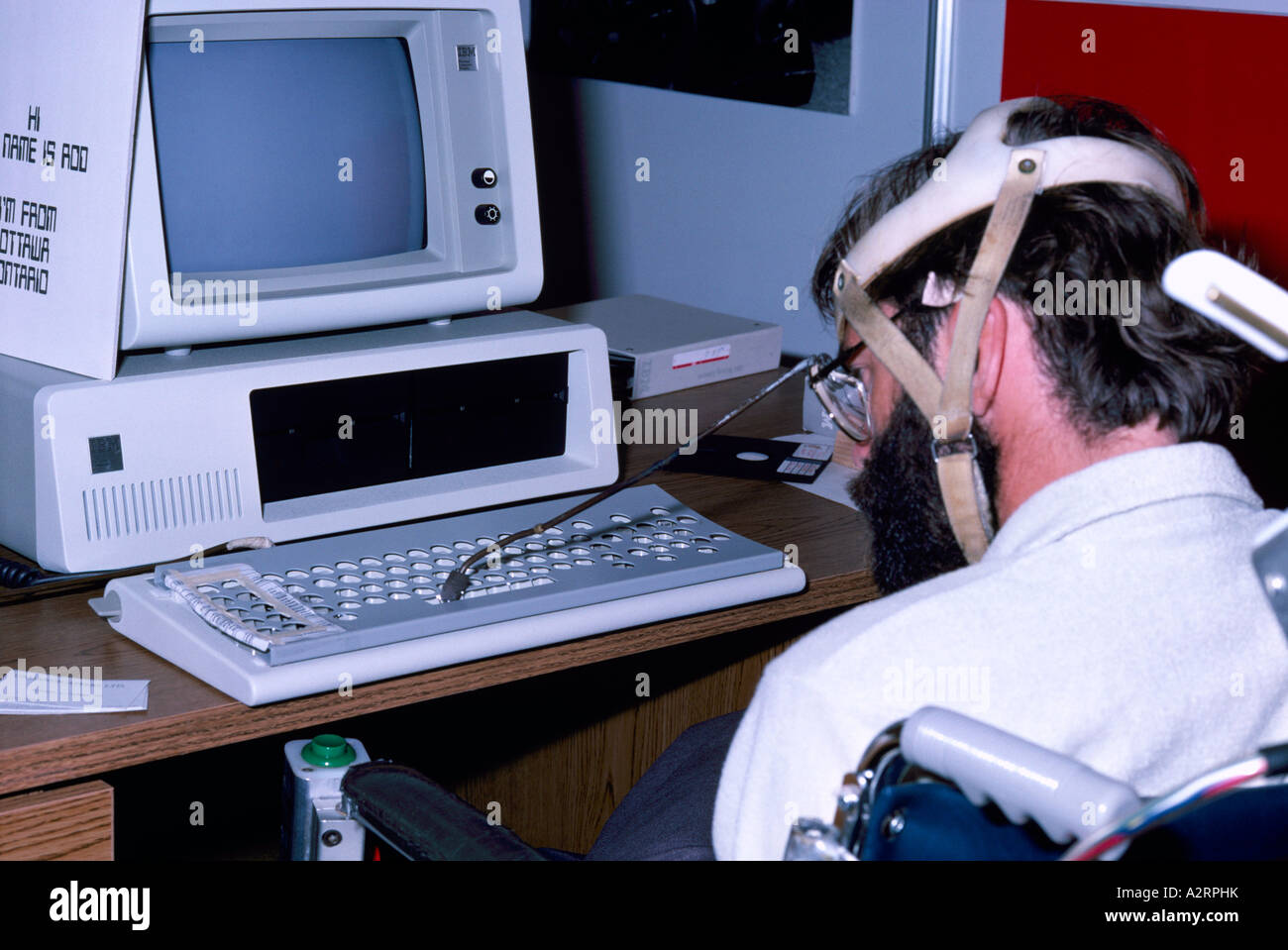 Disabled Man using Computer by typing on Keyboard with a Specially Stock Photo, Royalty Free