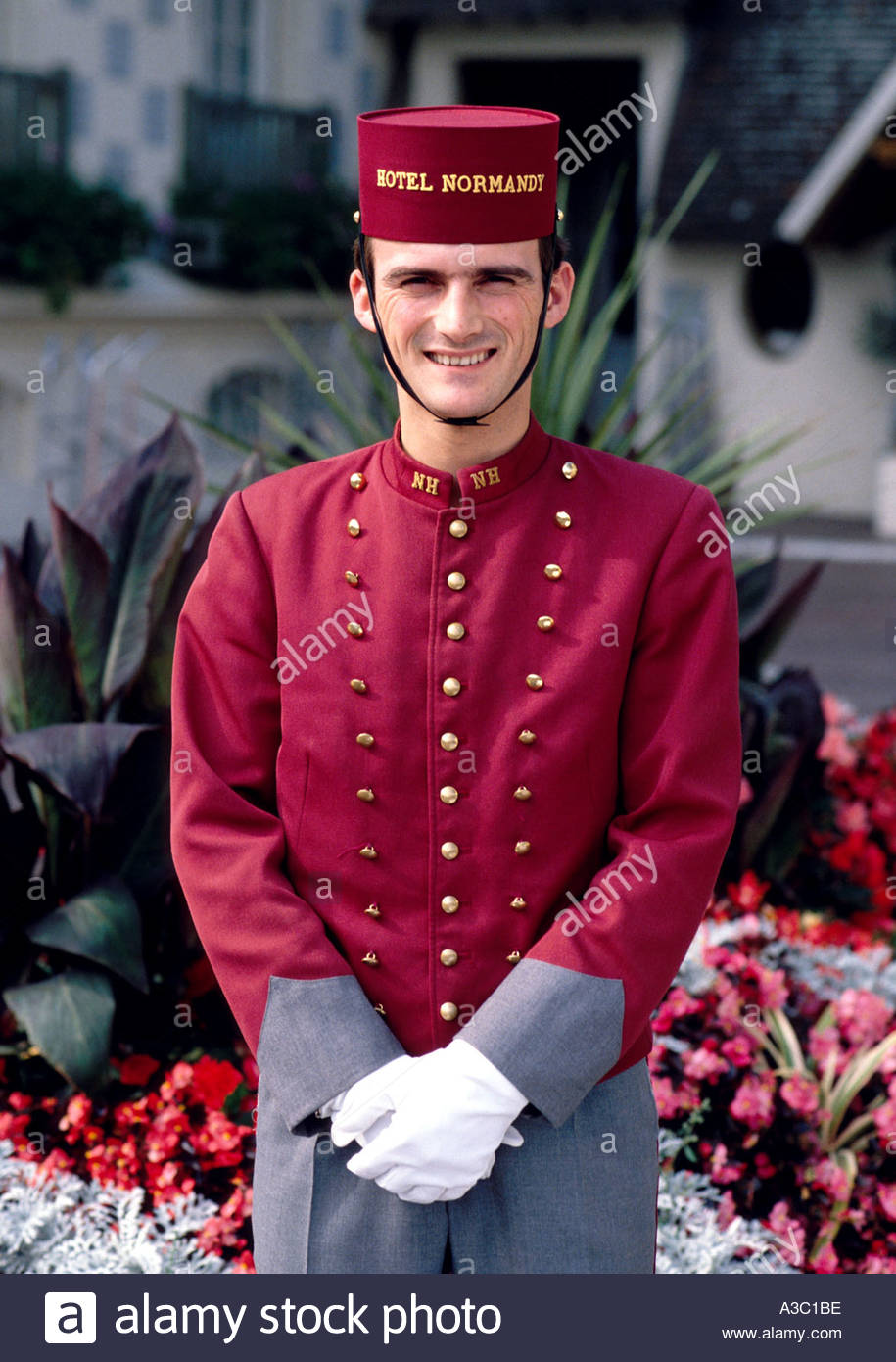 Portrait of a hotel doorman in uniform standing outside the Hotel Stock