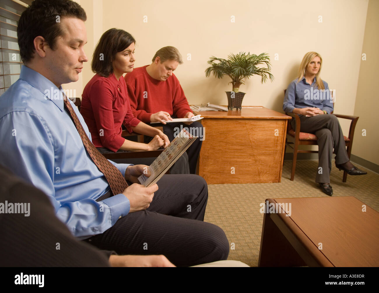 Patients waiting in a crowded medical office waiting room Stock Photo