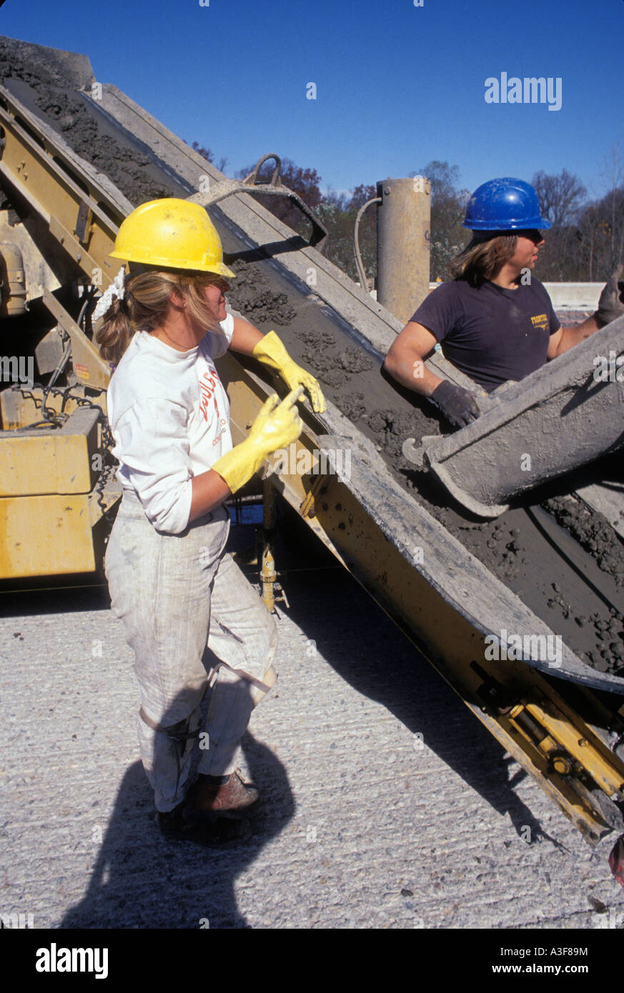 Female And Male Construction Workers Pouring Wet Concrete On New Stock Photo, Royalty Free Image