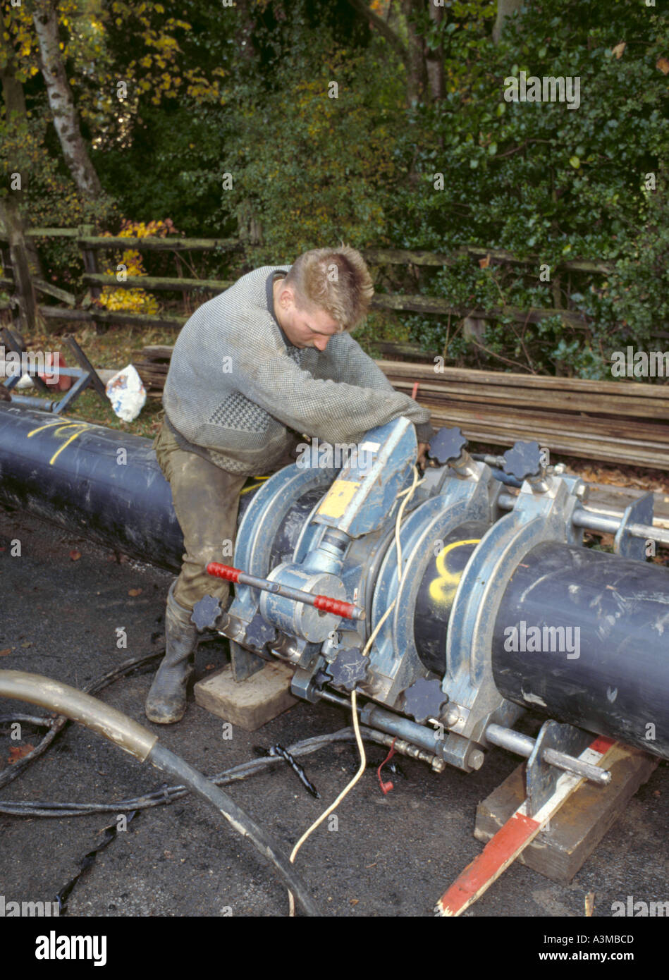 Workman welding two lengths of UPVC sewer pipe together, during Stock Photo, Royalty Free Image