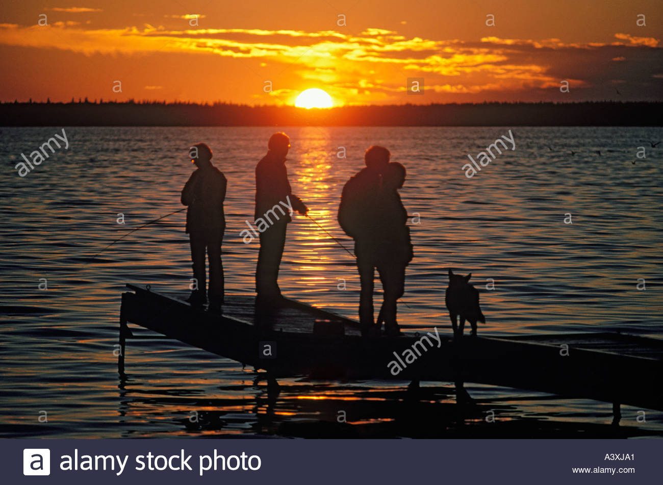 Family fishing on dock at sunset on Lac La Biche in Alberta Canada