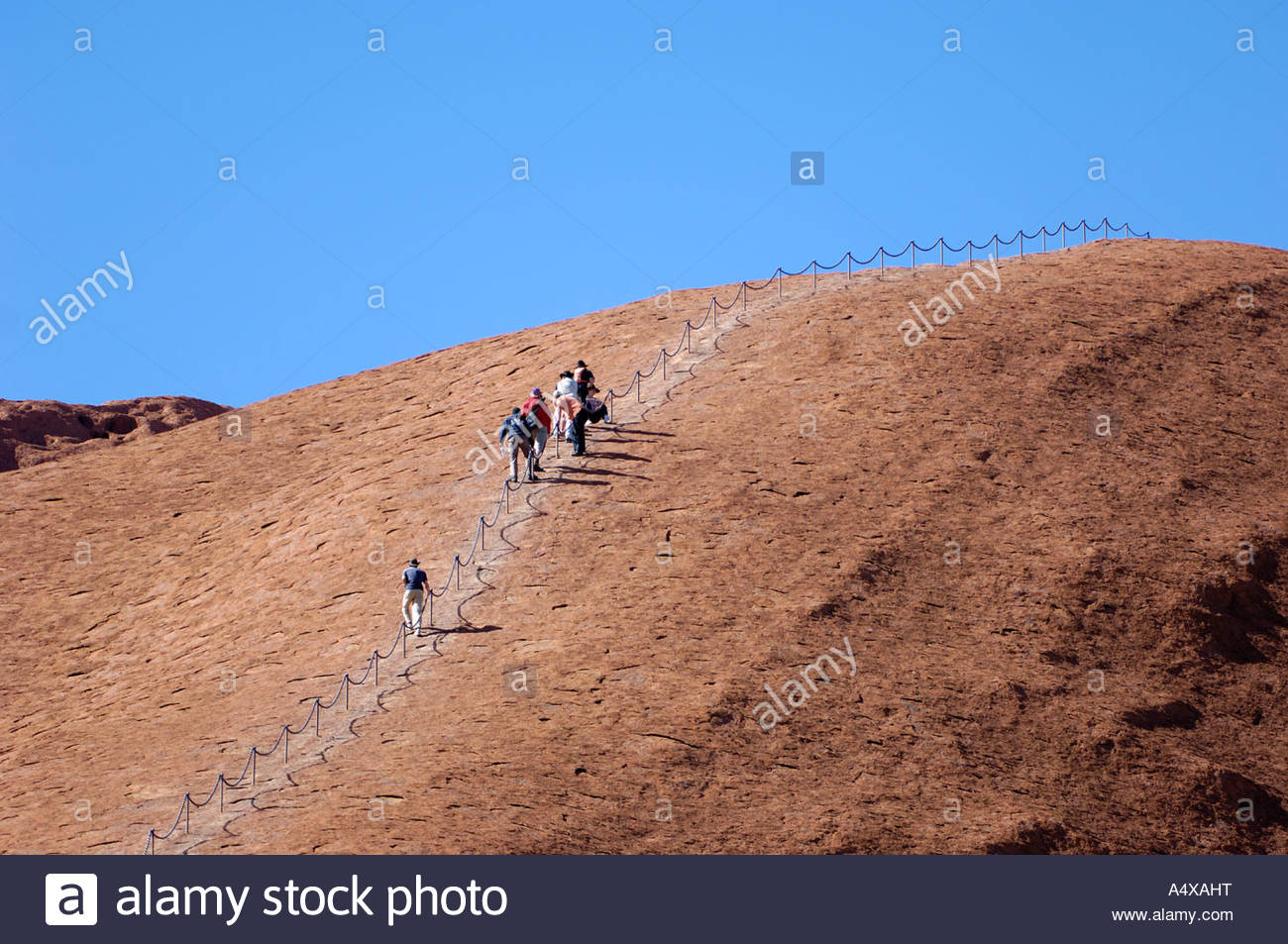 Tourists are climbing ayers rock, uluru, australia Stock Photo, Royalty