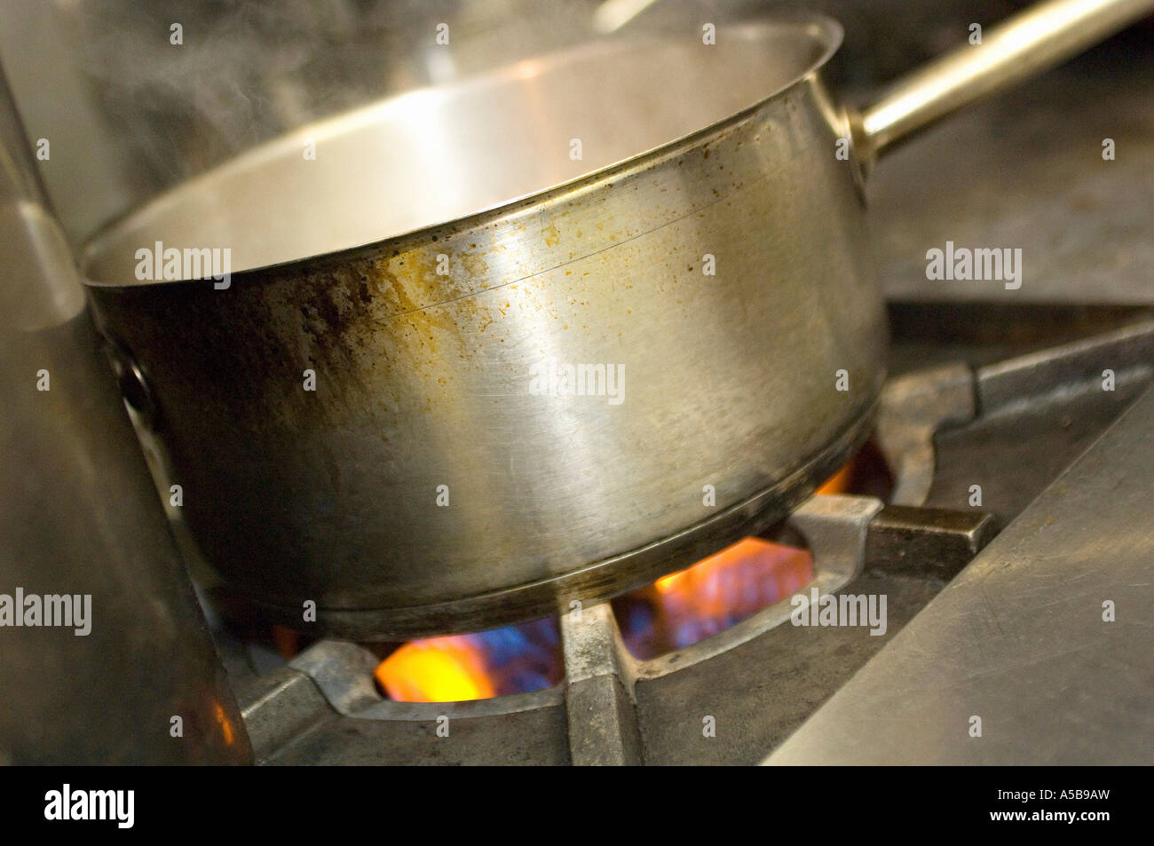 Restaurant Kitchen Gas Stove cooking pot on gas stove in restaurant kitchen stock photo Restaurant Kitchen Gas Stove cooking pot on gas stove in restaurant kitchen stock photo