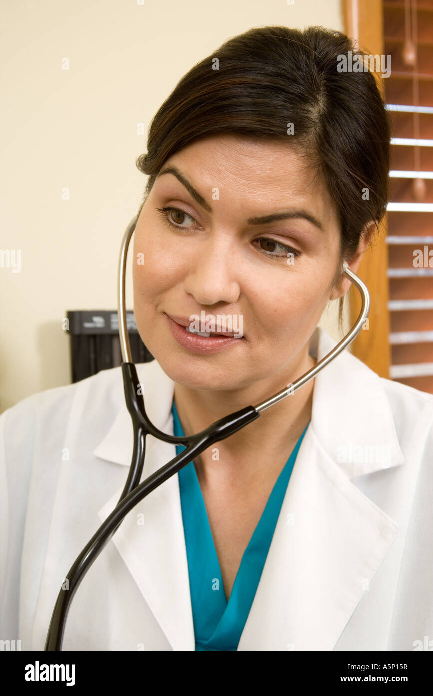 Female doctor listens to patient heart rate with stethoscope. Stock Photo - female-doctor-listens-to-patient-heart-rate-with-stethoscope-A5P15R