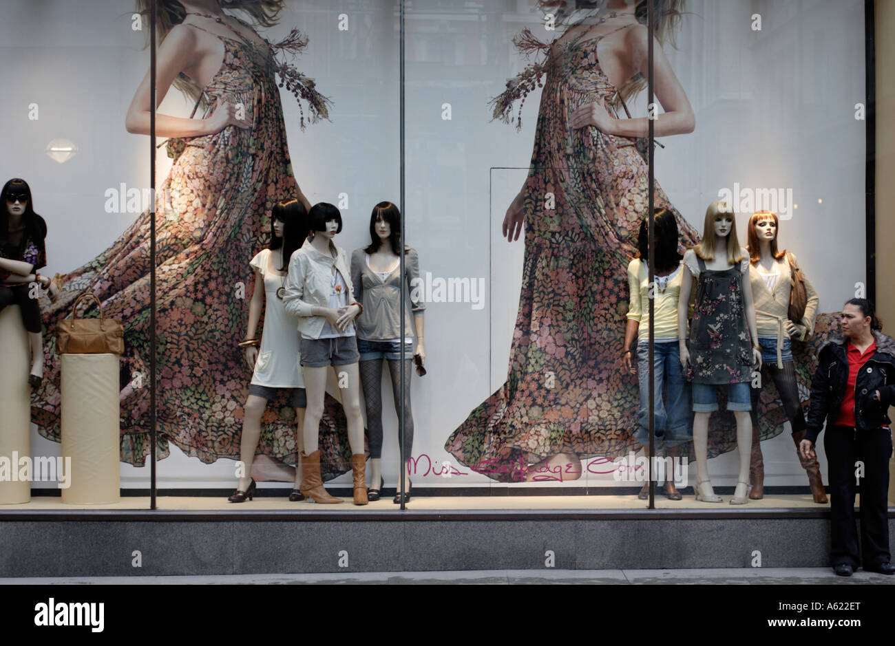 A Woman Standing At The Side Of Fashion Shop Window Display A Woman Standing At The Side Of Fashion Shop Window Display