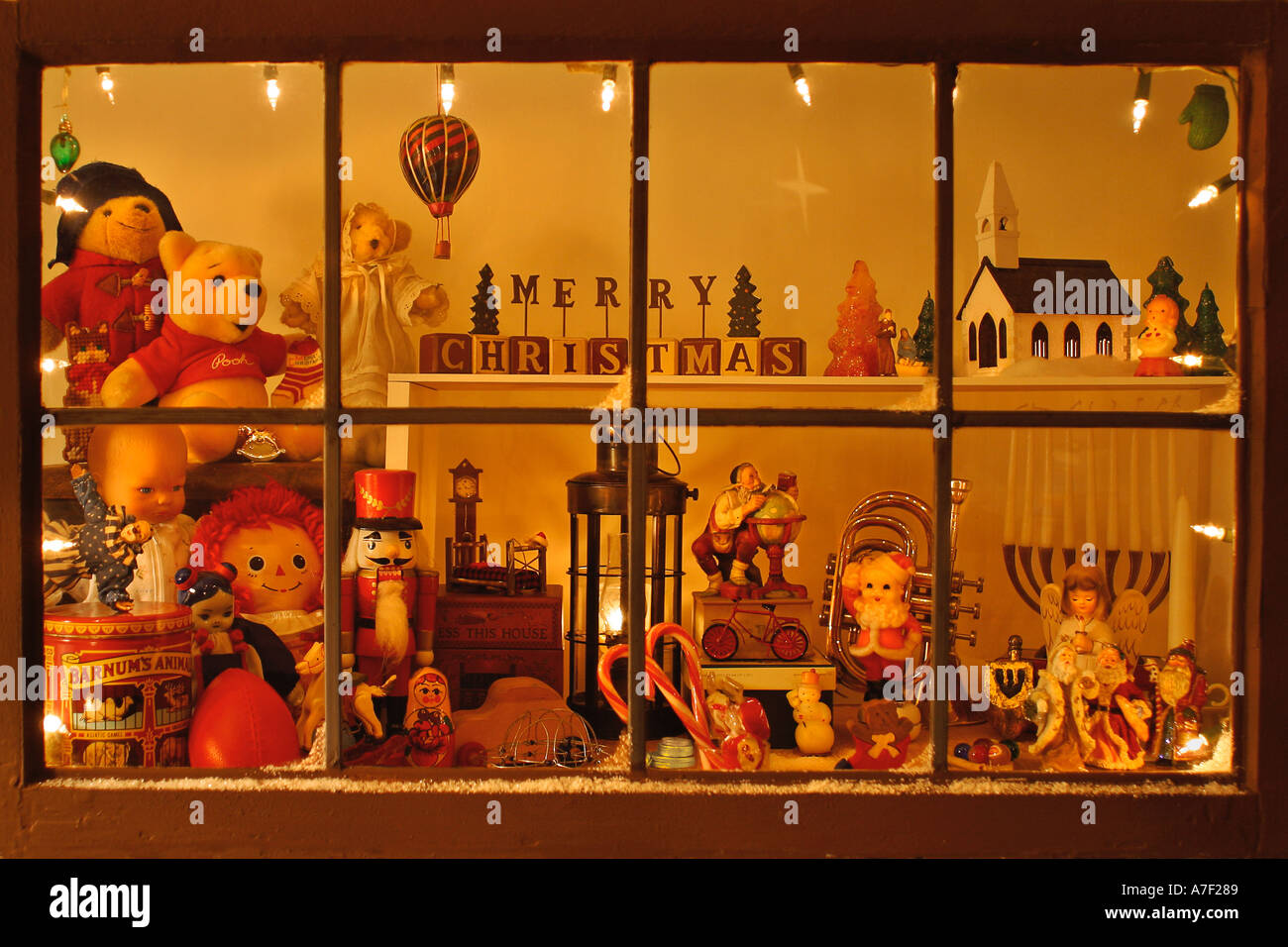 leaded glass shop window with snow on sill filled with trumpet christmas ornaments for the tree