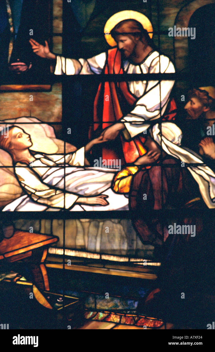 Jesus healing a sick child depicted on stained glass window. Palo Stock