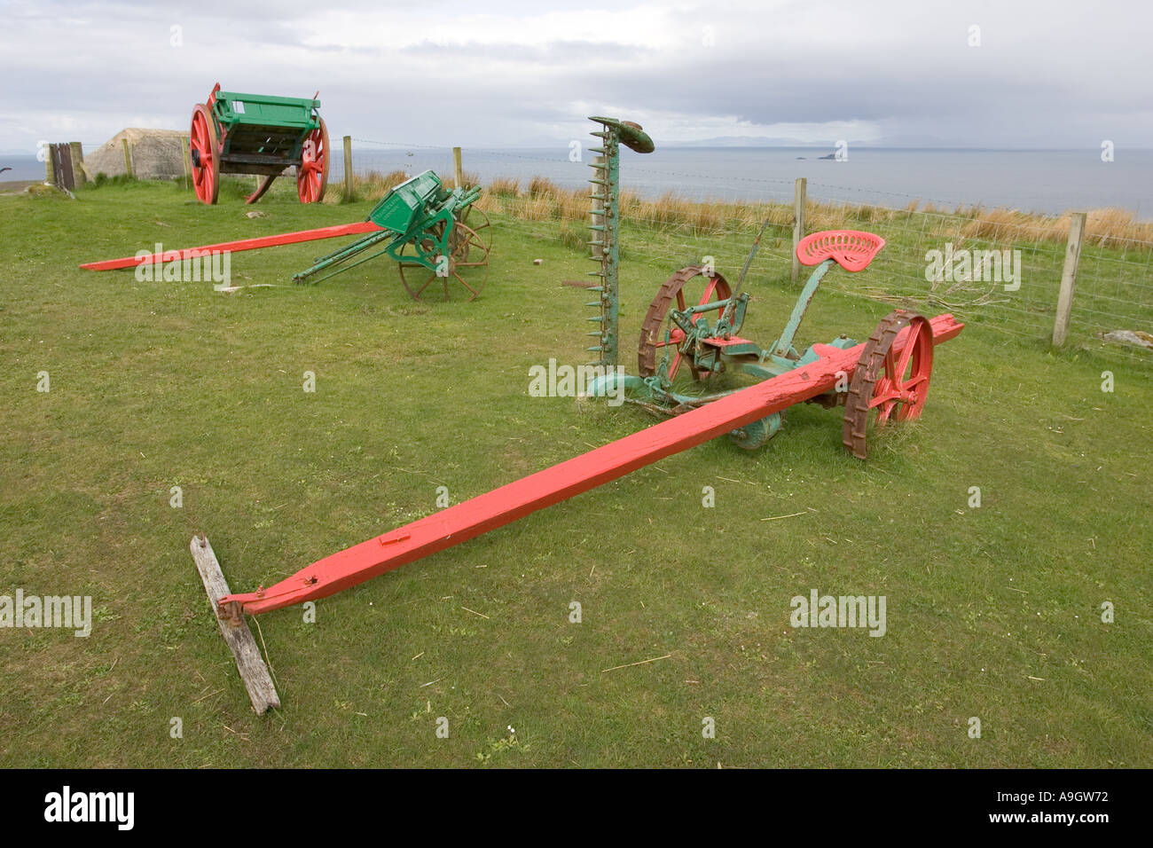 Old horse drawn harvester beside traditional crofters barn Museum of Stock Photo, Royalty Free