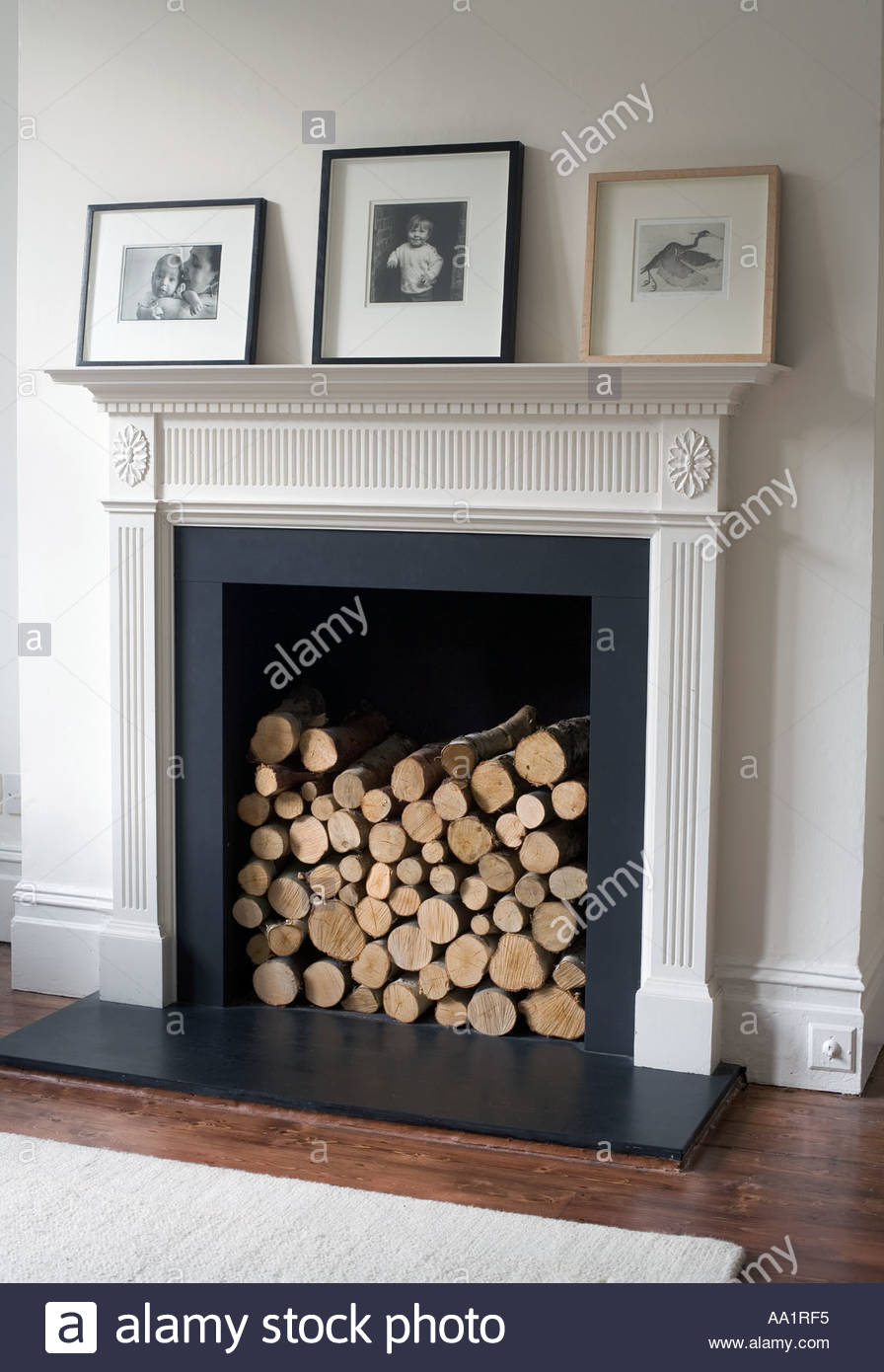 Fireplace and mantelpiece with photographs Logs fill the fireplace in Stock Photo Royalty Free Image: 4076532 - Alamy