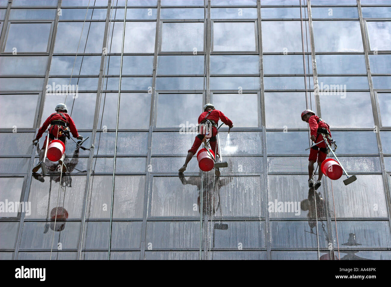 High rise window cleaners work suspended on ropes Orchard Road Stock