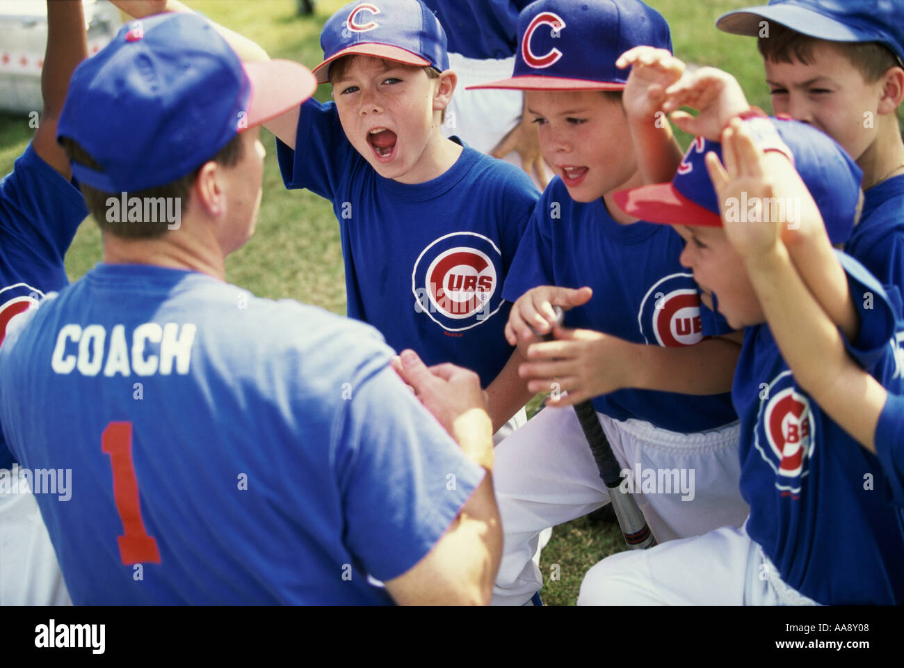 Little league baseball team cheering with their coach Stock Photo