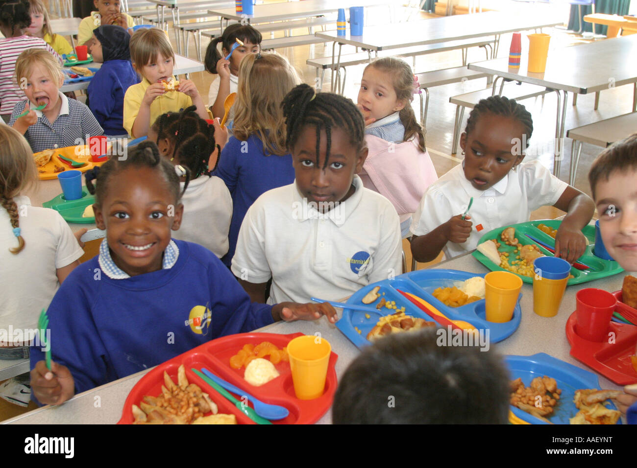 Primary school canteen with children eating lunch Stock Photo, Royalty