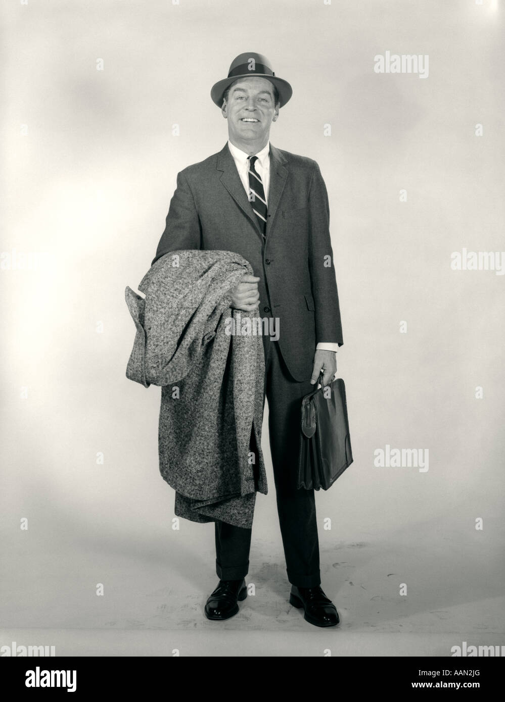 1950s 1960s STANDING SMILING MAN WEARING HAT BUSINESS SUIT OVERCOAT