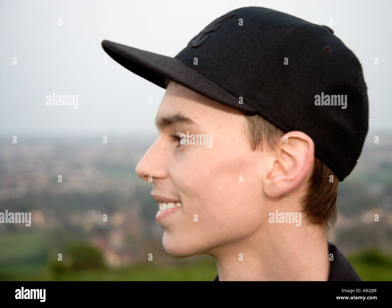 young-man-wearing-baseball-cap-smiling-portrait-side-view-close-up-AB2JBE.jpg