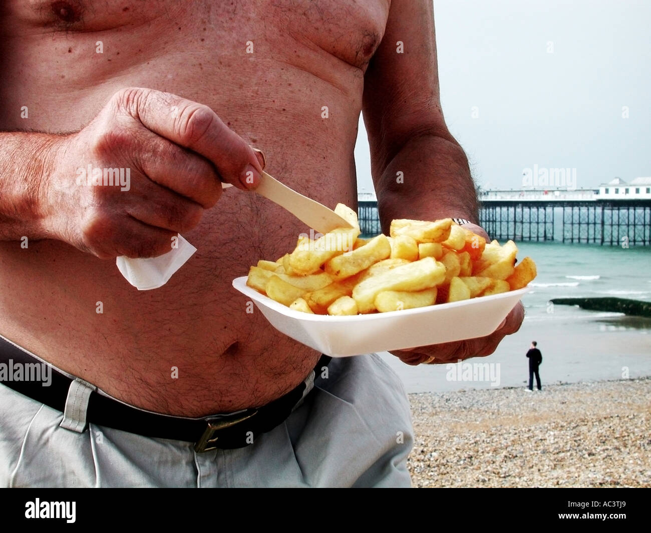 overweight-man-eating-chips-by-the-seasi