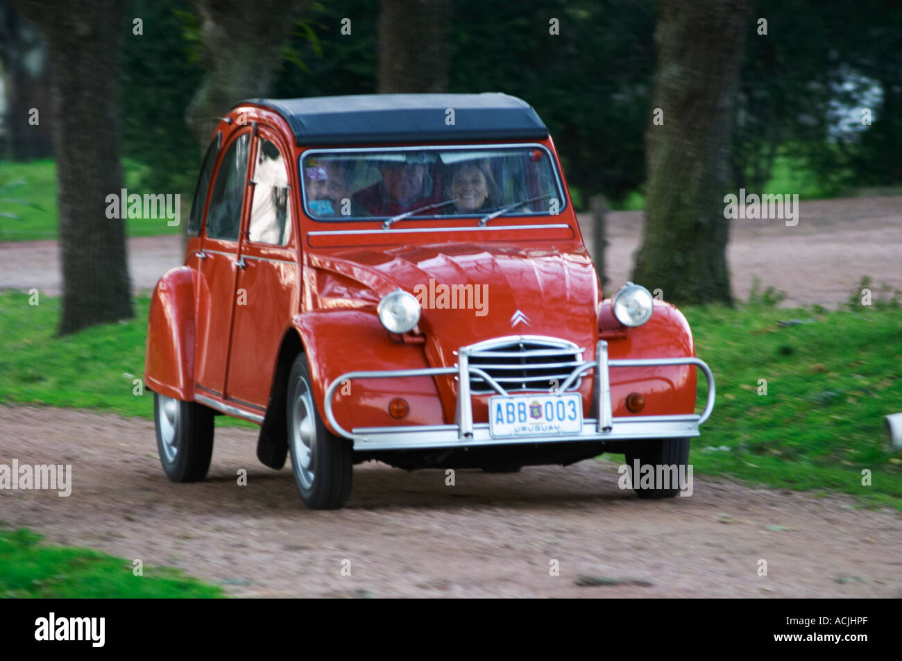an old red citroen 2cv 2 cv car with a smiling woman driving  elisa stock photo  royalty free