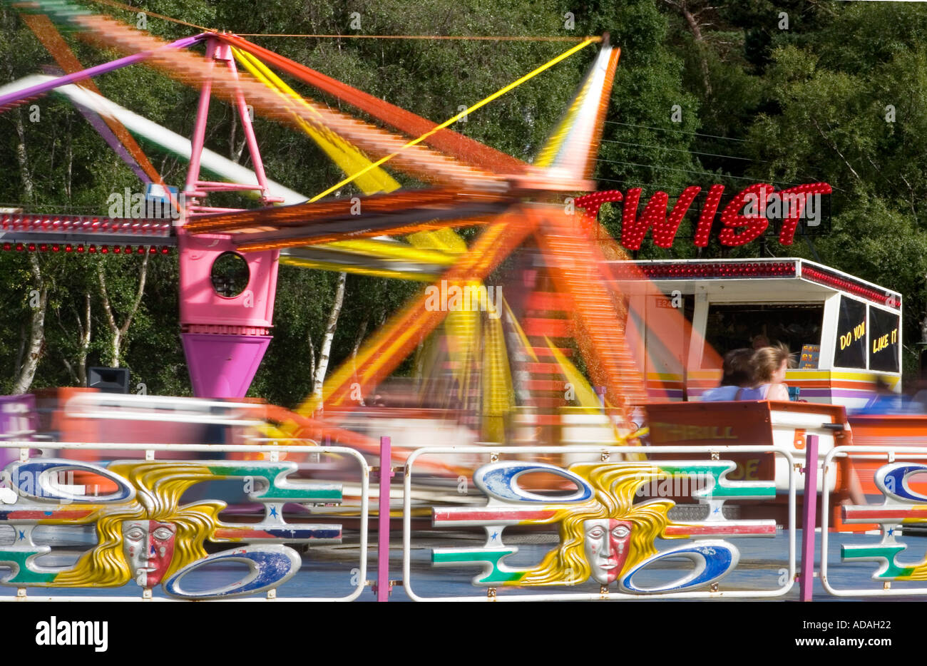 Twist ride passengers at amusement park fairground riders or Stock