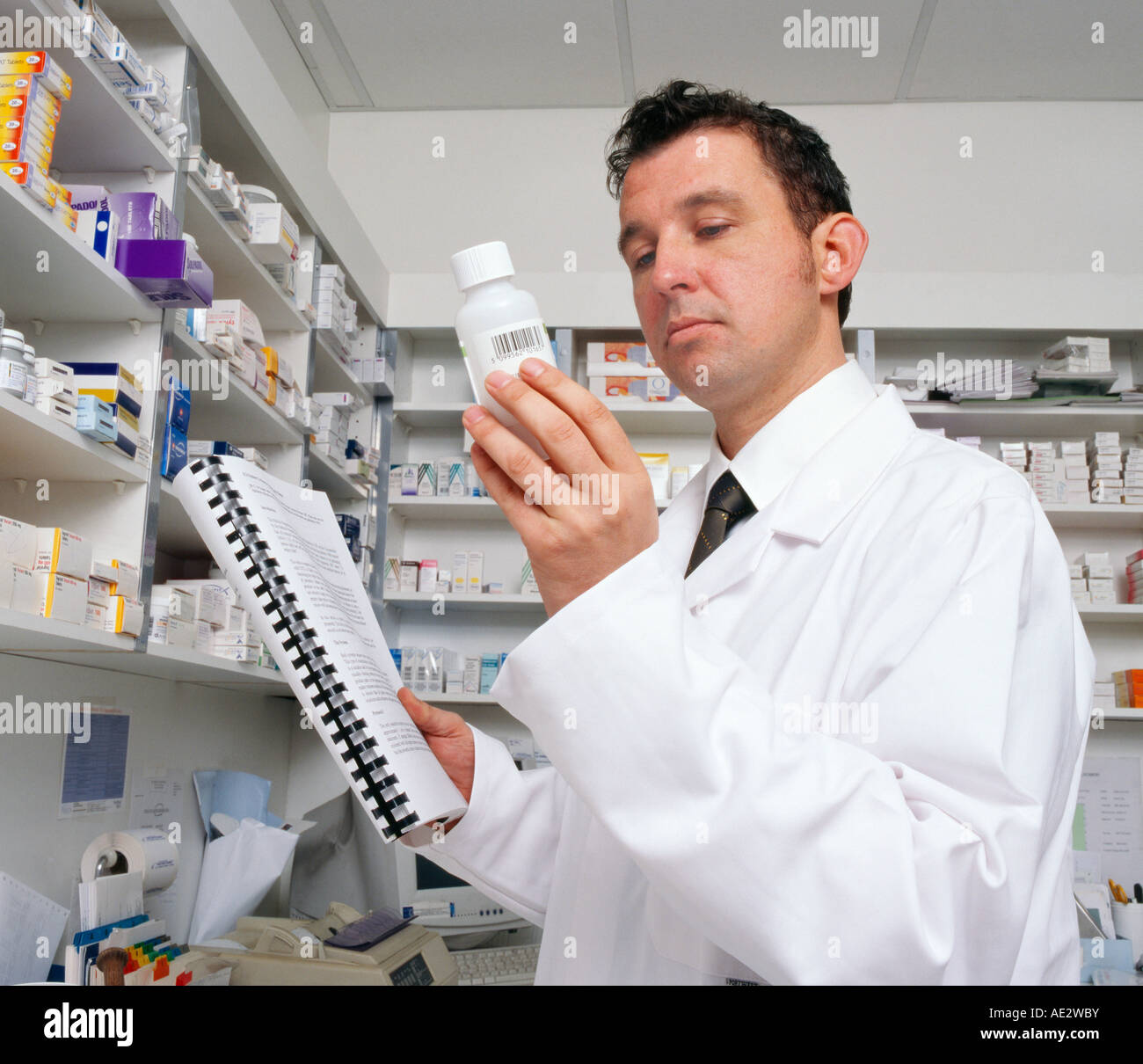 health care healthcare professional a pharmacist in a white lab coat examines a bottle of medication - Pharmacist Trainee health care healthcare professional a pharmacist in a white lab coat examines a bottle of medication - Pharmacist Trainee