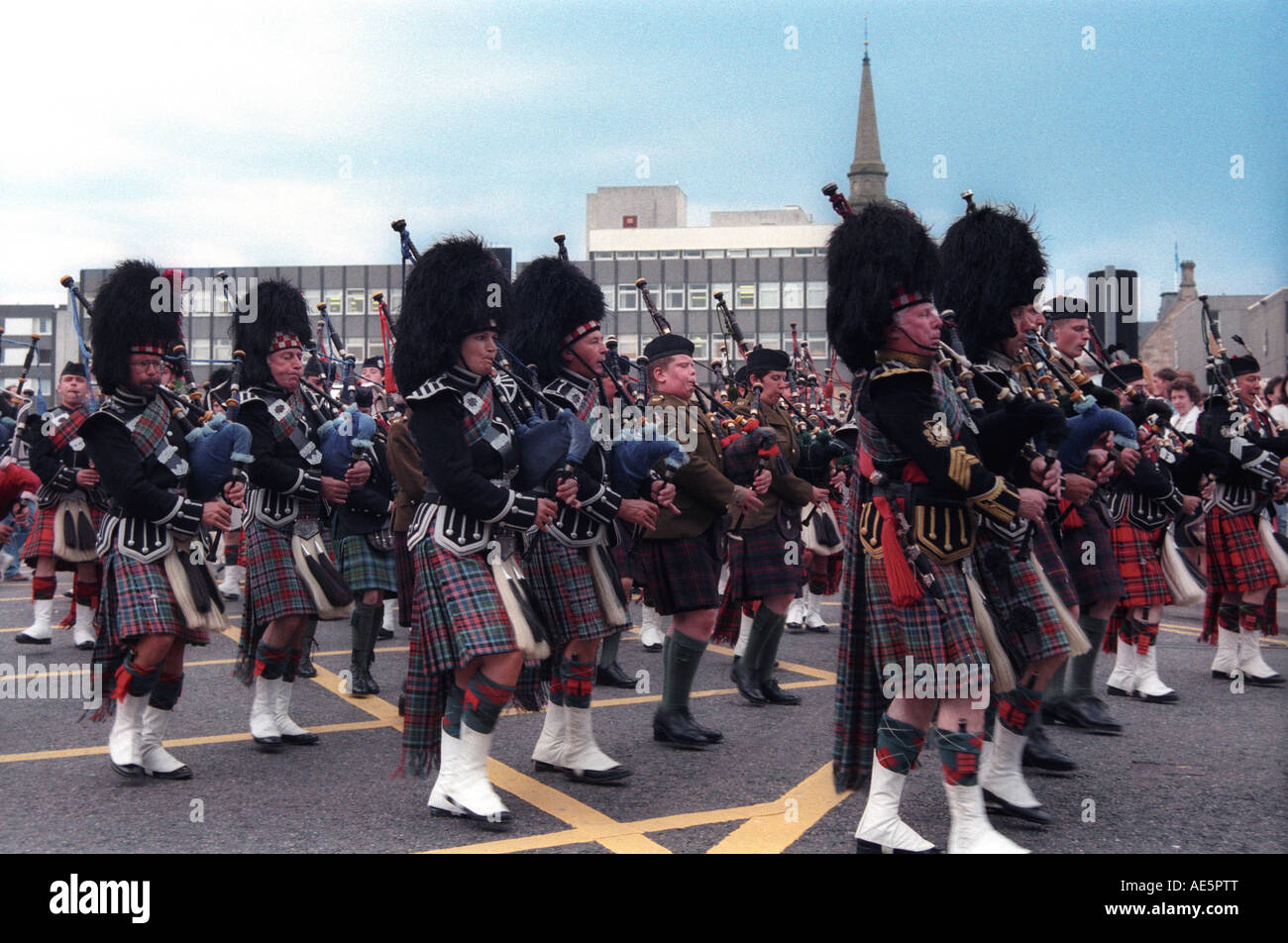 Scottish parade with people marching while playing bagpipes and Stock
