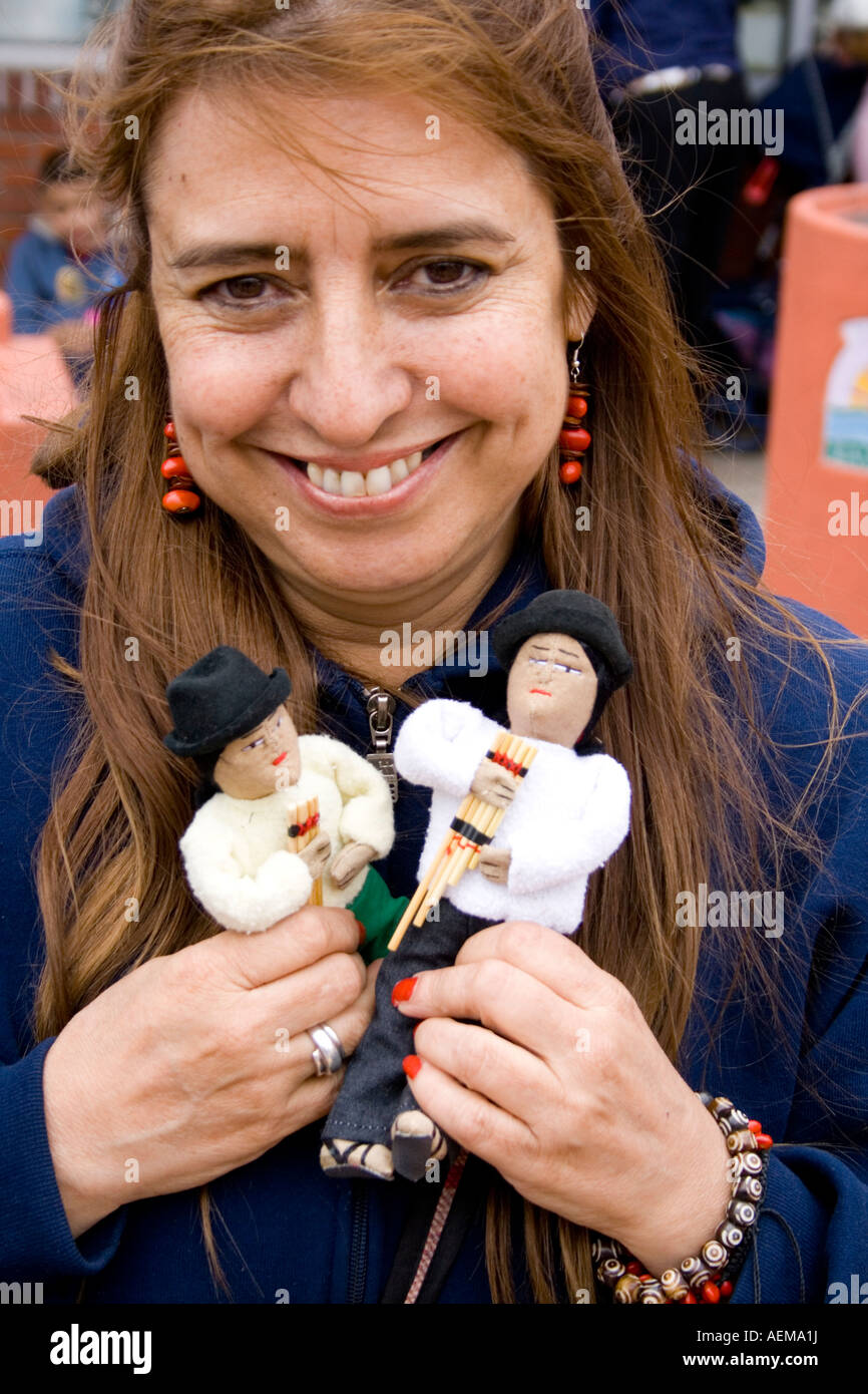 Hispanic vendor age 34 holding mountain men dolls with their tiny pan flutes. Cinco de - hispanic-vendor-age-34-holding-mountain-men-dolls-with-their-tiny-AEMA1J