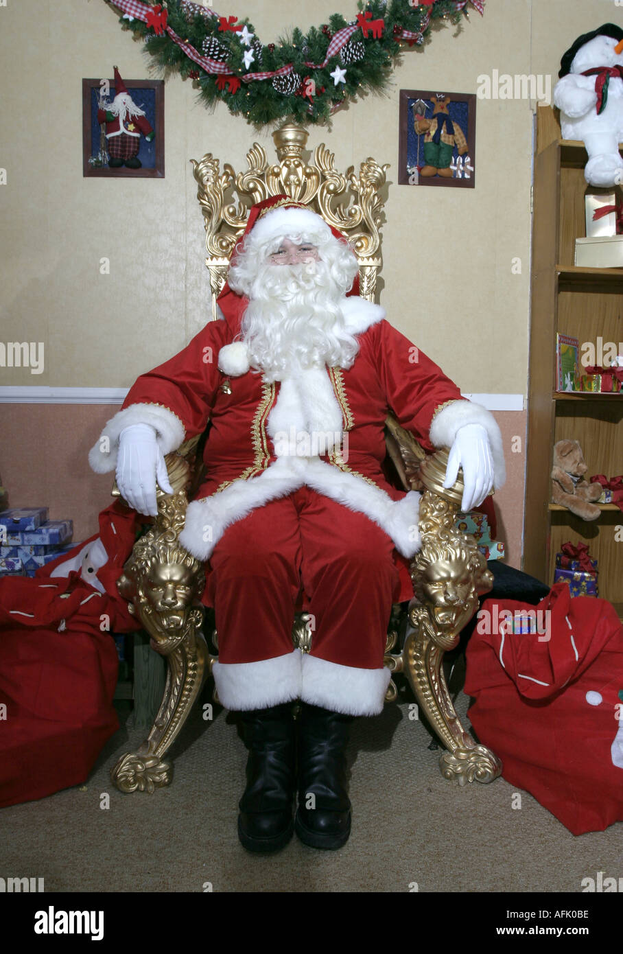 Santa Claus sitting on his throne in a grotto typical of a shopping