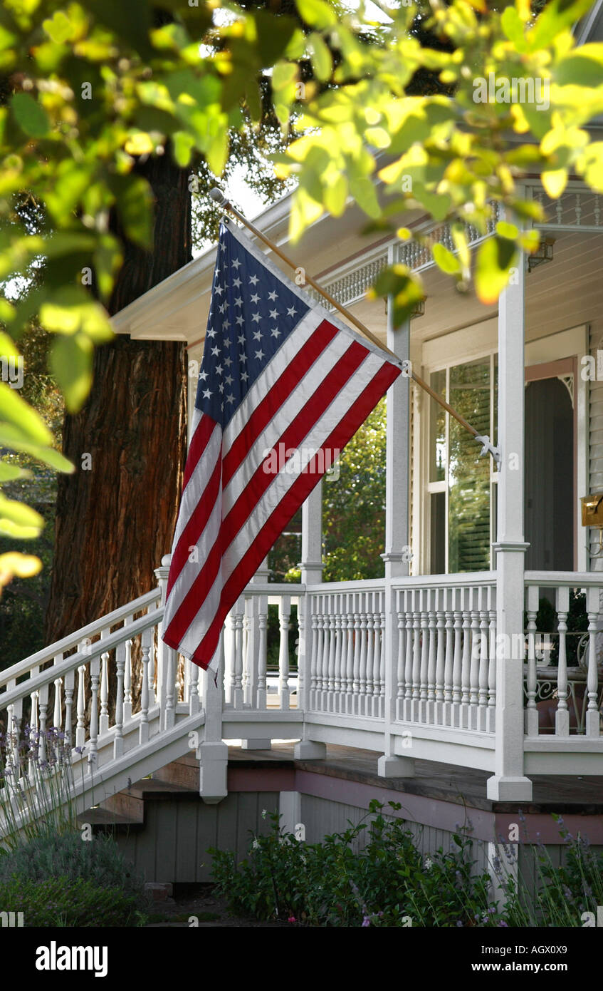 An American flag waves on the front porch of a small town Stock An American flag waves on the front porch of a small town Stock