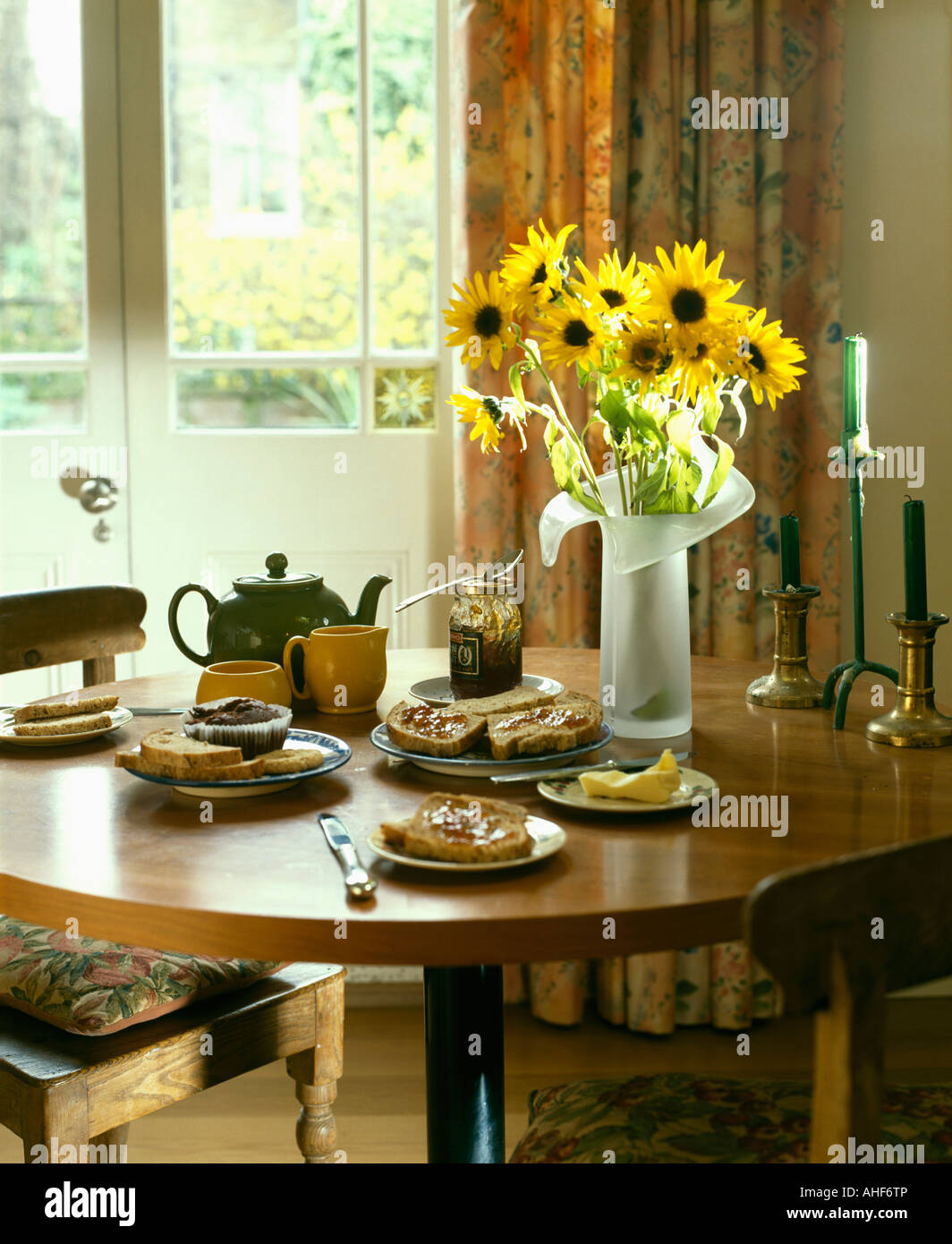 dining room with yellow sunflowers in glass vase on circular wood dining room with yellow sunflowers in glass vase on circular wood