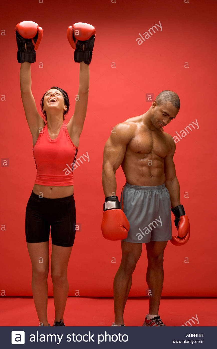 Female boxer celebrating victory over male Stock Photo, Royalty Free