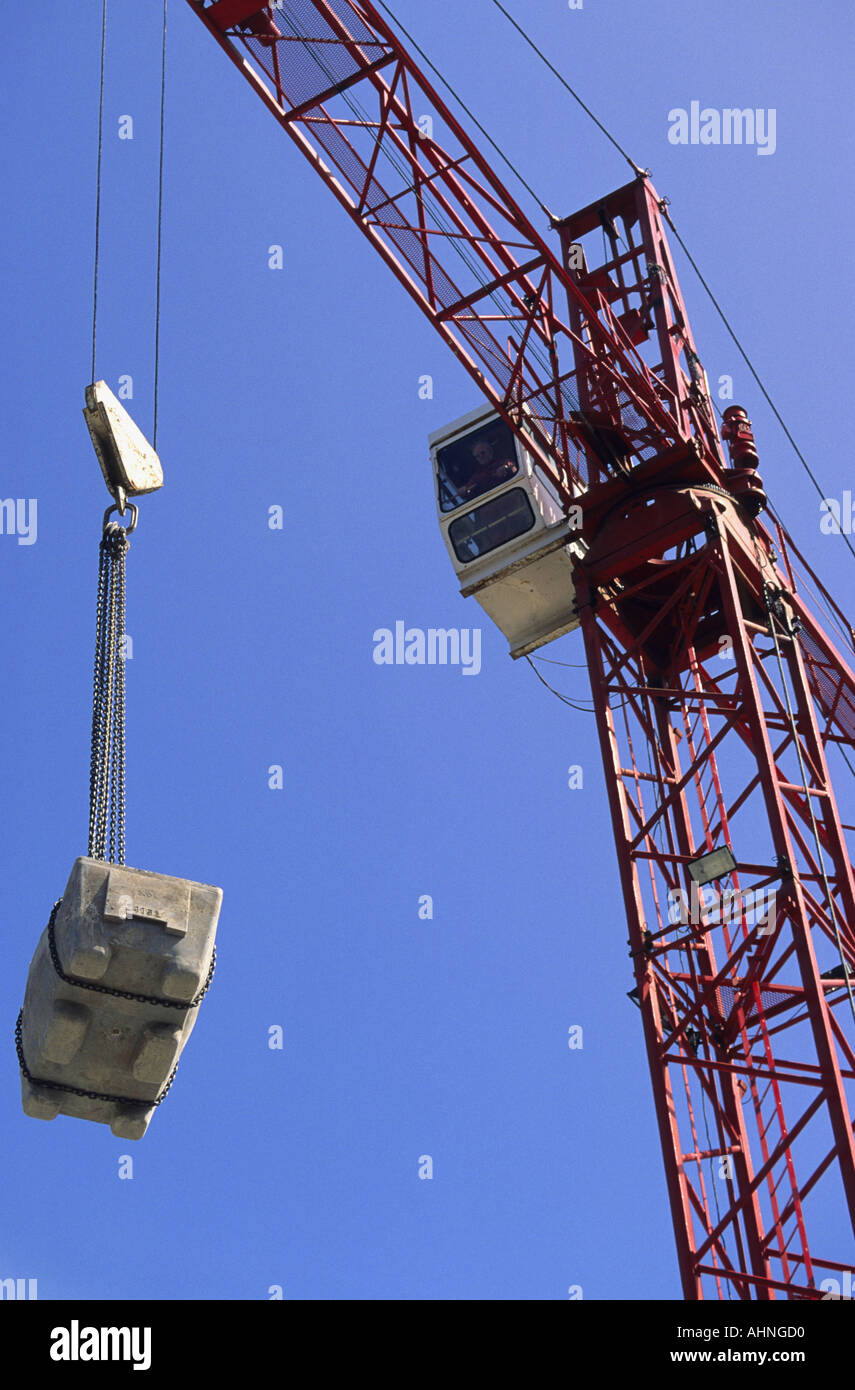 crain driver manouvering crane hoist carrying heavy load on building
