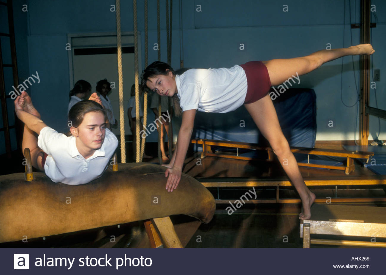 Girls warm up for gymnastics class on gym equipment Secondary school