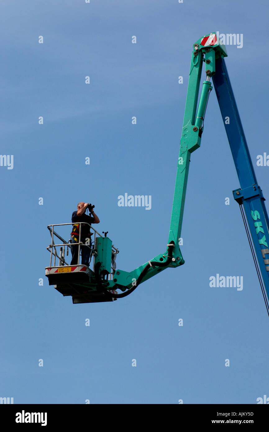 Man in cherry picker carrying out line of sight survey for Stock Photo
