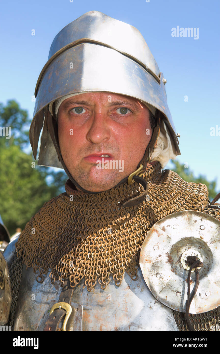 Closeup of man in suit of shining armour holding pike at medieval reenactment Stock Photo - closeup-of-man-in-suit-of-shining-armour-holding-pike-at-medieval-AK1GW1