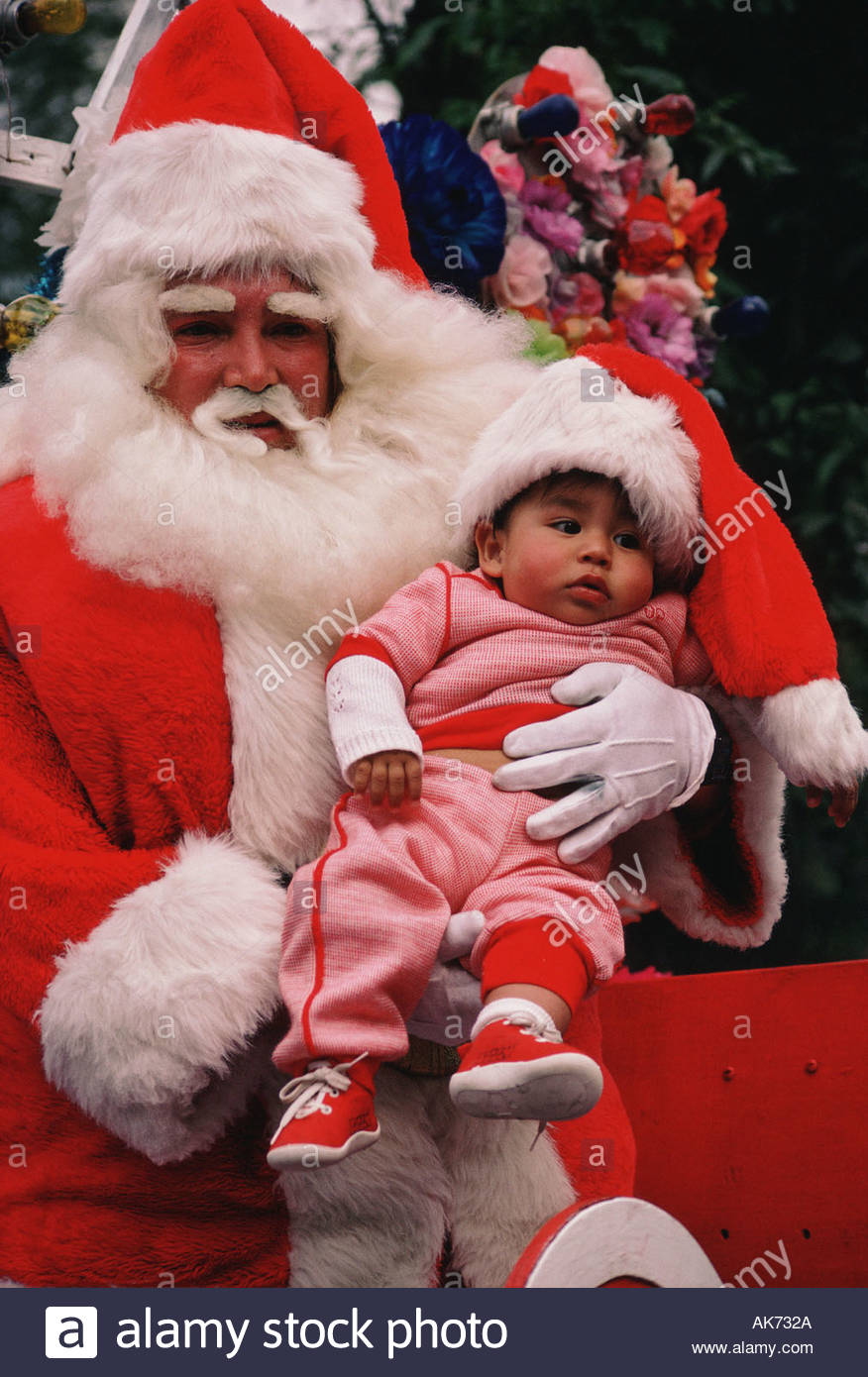 MEXICO Mexico City Santa Claus on Christmas Day carrying baby Stock