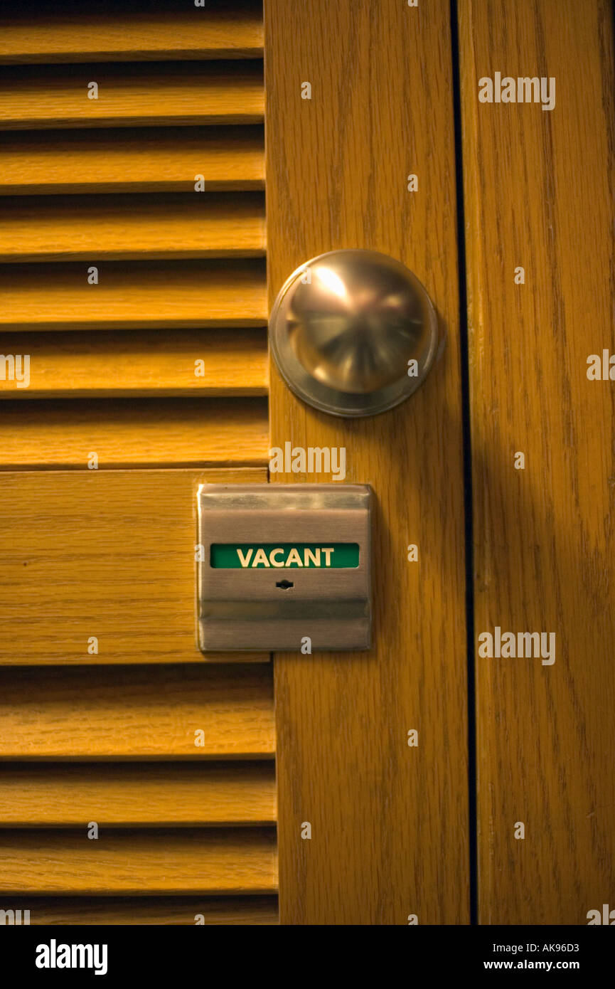Bathroom Stall Knob vacant or unoccupied sign and brass knob on louvered door to Bathroom Stall Knob vacant or unoccupied sign and brass knob on louvered door to