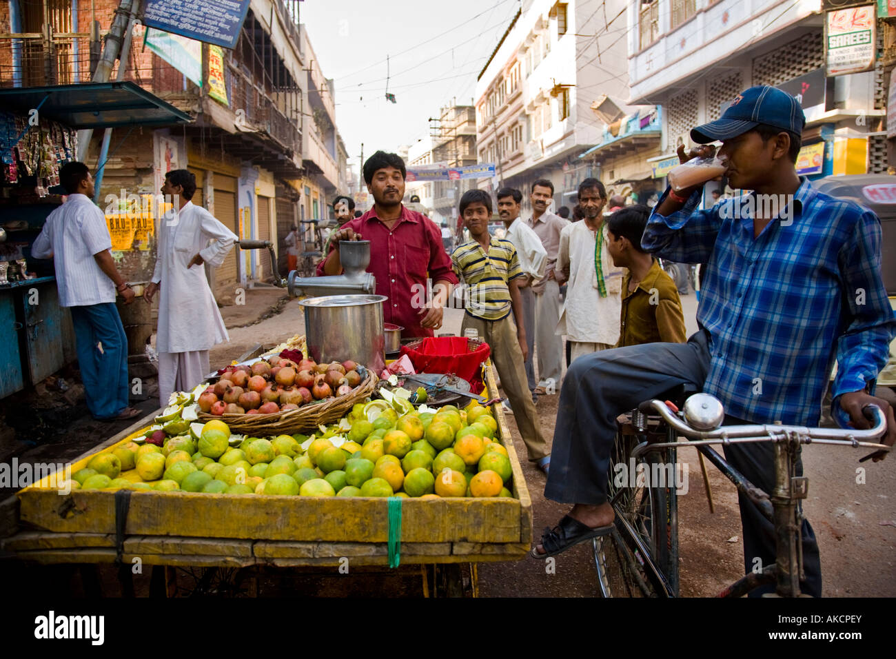 A street vendor sells fresh fruit juice drinks from his cart Stock