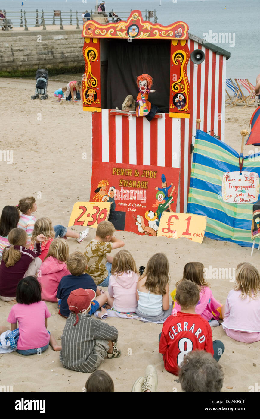 Children watching puppet show on beach Stock Photo, Royalty Free Image