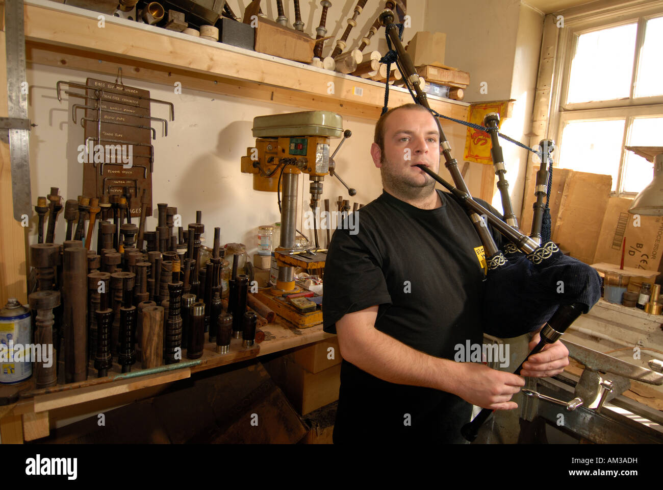 bagpipe player in of Bagpipe Galore shop royal mile Stock