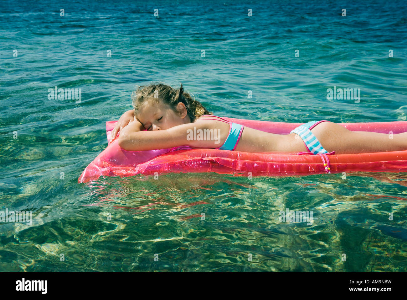 Young girl sleeping floating on an inflatable raft Stock Photo, Royalty
