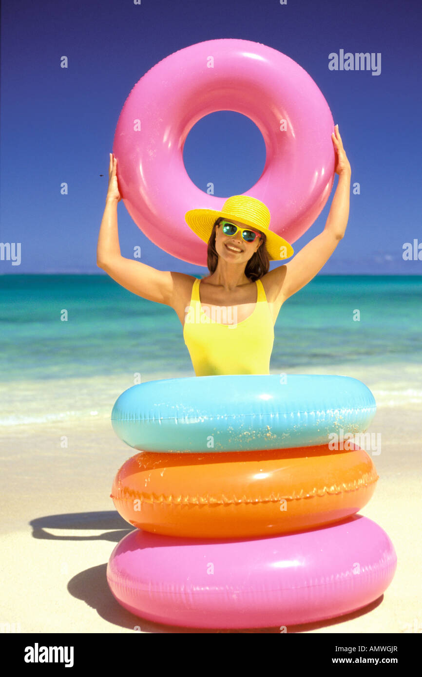 USA, Hawaiian Islands. Woman posing with inner-tubes on tropical
