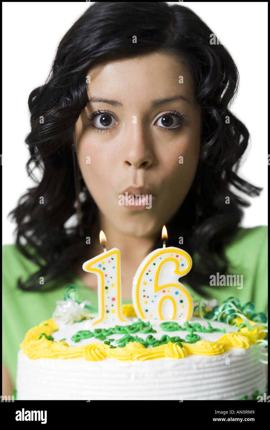 Portrait of a teenage girl blowing out candles on her birthday cake