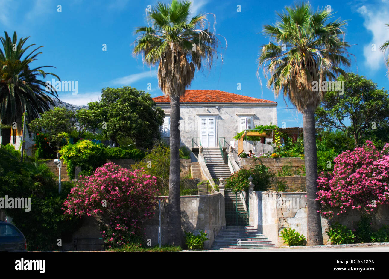 a beautiful beach house with flowers in the garden framedtwo a beautiful beach house with flowers in the garden framedtwo