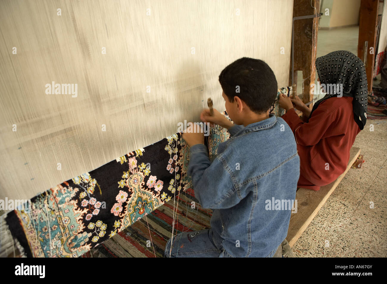 Children weaving carpets in carpet factory near Cairo Egypt Stock Photo