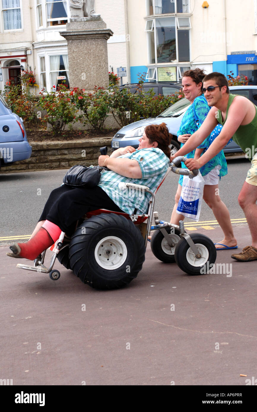 An overweight disabled female is pushed by her husband in a converted